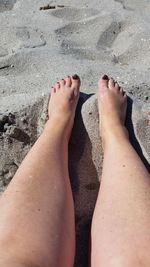 Low section of woman legs on sand