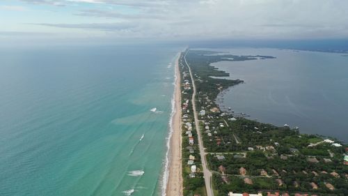 High angle view of sea by city against sky