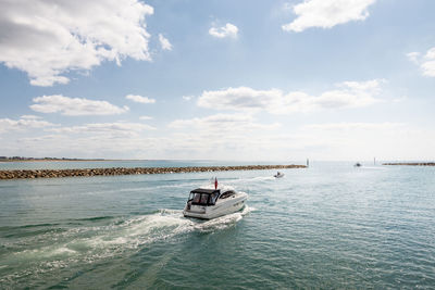 Boat sailing in sea against sky