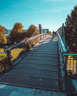 Footbridge over trees against sky