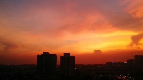 Silhouette cityscape against sky during sunset