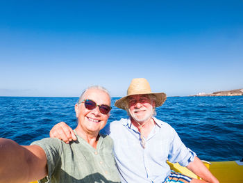 Portrait of smiling friends on sea against sky