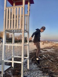 Full length side view of man standing against sky