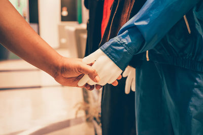 Cropped image of woman holding mannequin in shopping mall