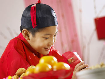 Close-up of teenage boy in traditional clothes looking in envelope