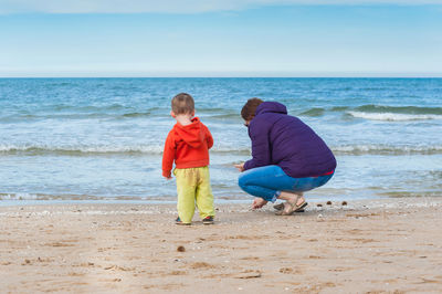 Rear view of woman with son at beach