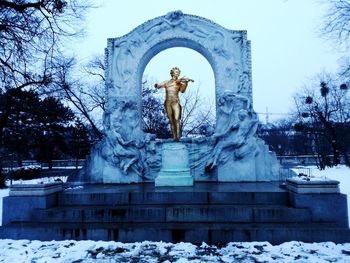 Statue against bare trees during winter