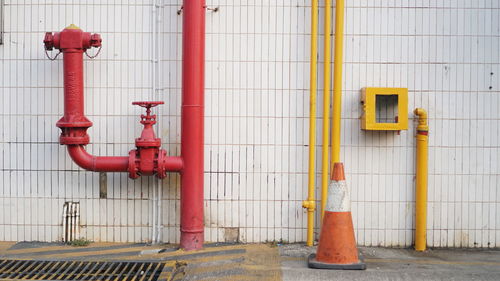 Red pipe on floor against wall