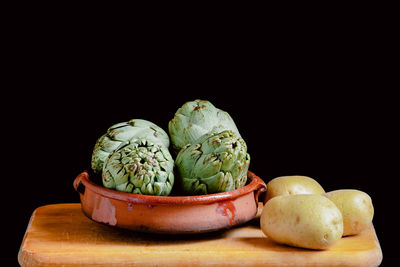 Still life of artichokes and potatoes on a kitchen wooden board