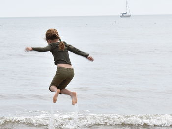 Full length of girl jumping on beach
