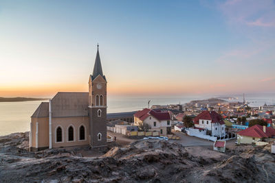 View of church at beach against sky