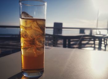 Close-up of drink on table by sea against sky