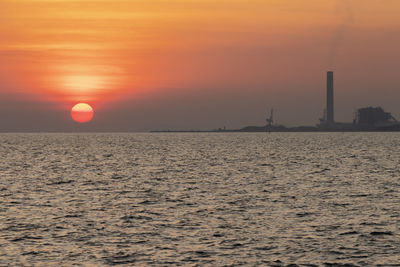 Scenic view of sea against orange sky