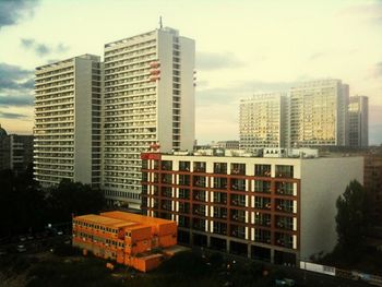 Buildings in city against cloudy sky