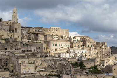 Buildings in city against cloudy sky