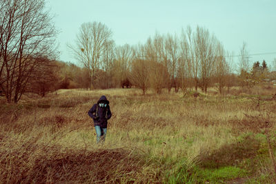 Rear view of man with mask walking on field