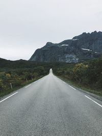 Road amidst mountains against clear sky