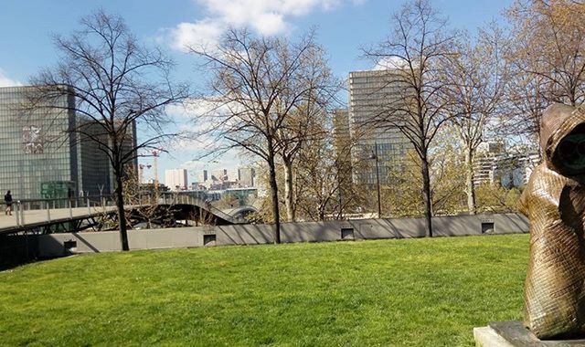 architecture, built structure, building exterior, bare tree, tree, city, grass, bridge - man made structure, sky, connection, day, residential building, river, outdoors, incidental people, building, capital cities, sunlight, lawn, arch bridge