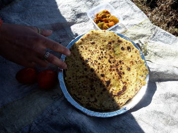 High angle view of hand holding food on table