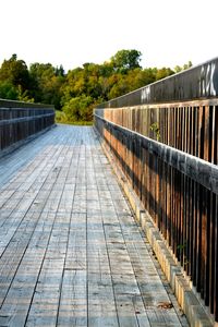 Footbridge over river against clear sky