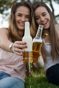 Happy friends toasting beer bottles