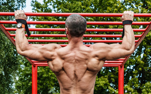 Rear view of man exercising in playground