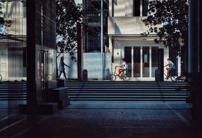 People walking on street amidst buildings in city