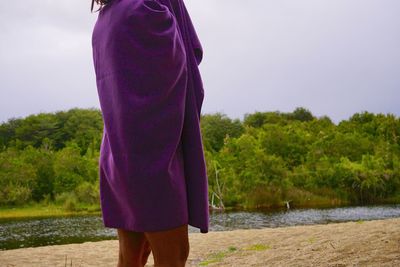 Rear view of woman standing on field against sky