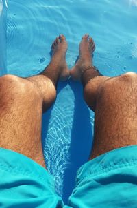 Low section of woman relaxing in swimming pool