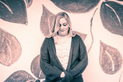 Woman standing against patterned wall