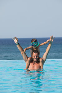 Portrait of man in swimming pool against sea