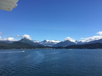 Scenic view of lake and mountains against blue sky