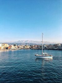 Sailboats in sea against clear blue sky