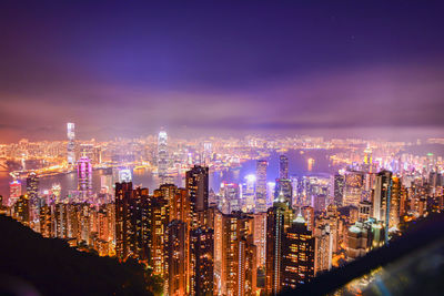 Illuminated cityscape against sky at night