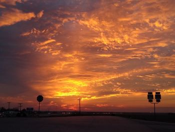 Silhouette of road against dramatic sky during sunset