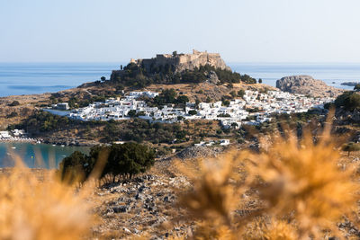 Panoramic shot of townscape by sea against clear sky