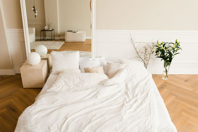 A cozy bed on the floor, a large mirror in a classic modern bedroom. interior of the house