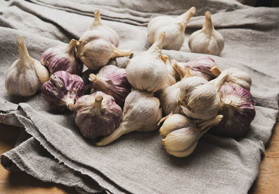 Bunch of fresh garlic on a gray linen napkin, close up