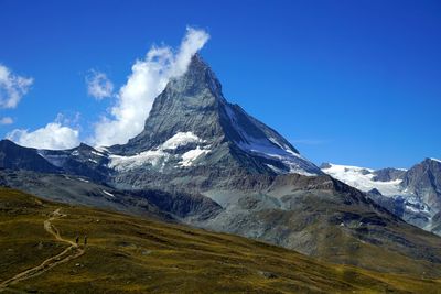 Scenic view of snowcapped mountains against blue sky