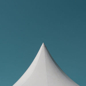 Low angle view of parasol against clear blue sky