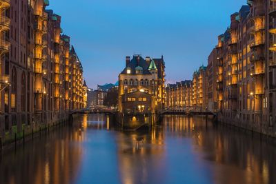 Illuminated buildings against sky at night