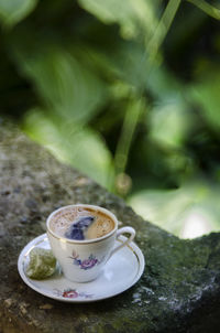 Close-up of coffee cup on rock