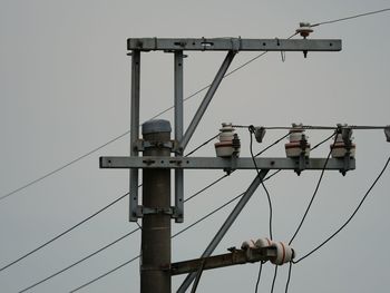 Low angle view of electricity pylon against sky