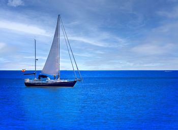 Sailboat on sea against blue sky.