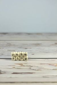 Close-up of text on wooden table against sea