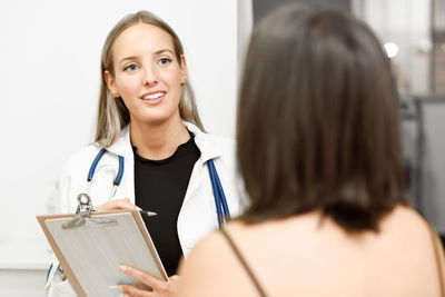 Smiling female doctor having discussion with patient at clinic
