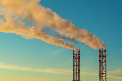 Low angle view of smoke stack against sky