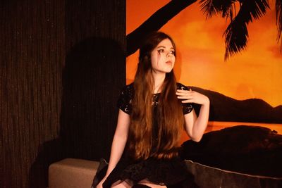 Young woman with halloween make-up sitting in studio