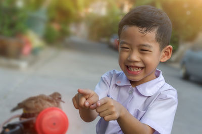 Cheerful boy pointing at bird outdoors