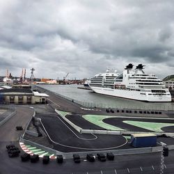 Cars on road against cloudy sky